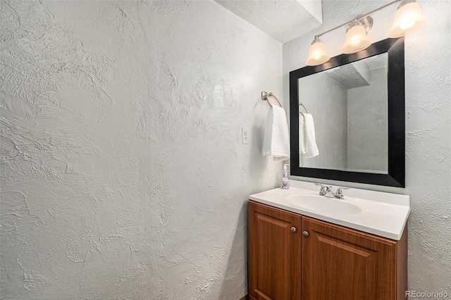 bathroom featuring vanity and a textured wall