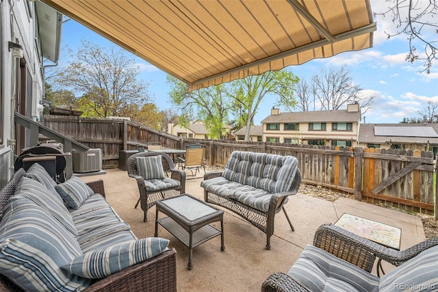 view of patio / terrace with a fenced backyard, an outdoor living space, and central AC