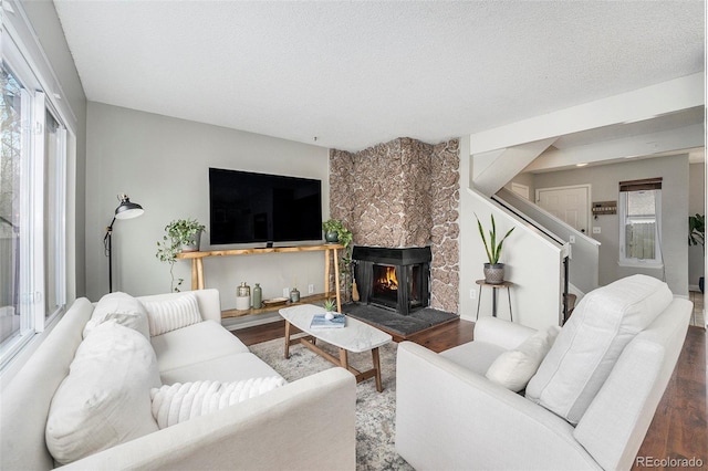 8873 Yukon St, Broomfield, CO 80021 - living room with wood finished floors, a fireplace, stairs, and a textured ceiling