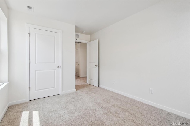 unfurnished bedroom featuring light carpet