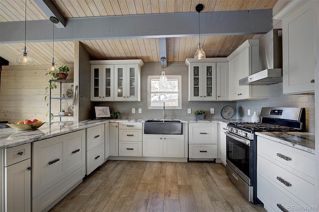 kitchen featuring sink, gas stove, white cabinetry, decorative light fixtures, and beamed ceiling