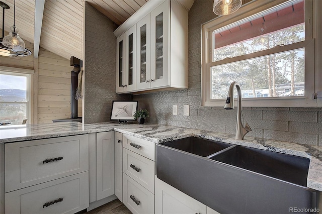 kitchen featuring white cabinetry, sink, pendant lighting, and wood ceiling