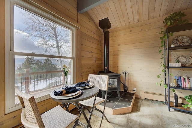 interior space with hardwood / wood-style floors, lofted ceiling, a wood stove, a water view, and wooden ceiling