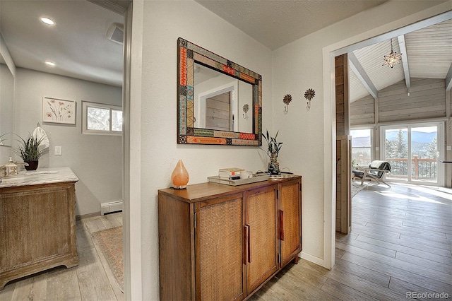 hall featuring a baseboard heating unit, vaulted ceiling with beams, and light hardwood / wood-style flooring