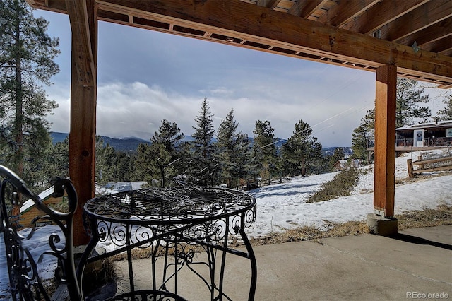 snow covered patio with a mountain view