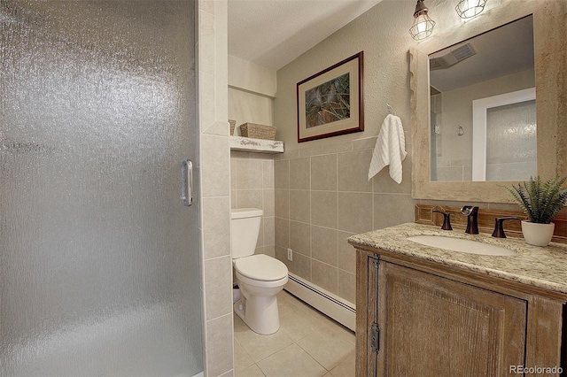 bathroom with tile patterned floors, an enclosed shower, tile walls, vanity, and a baseboard heating unit