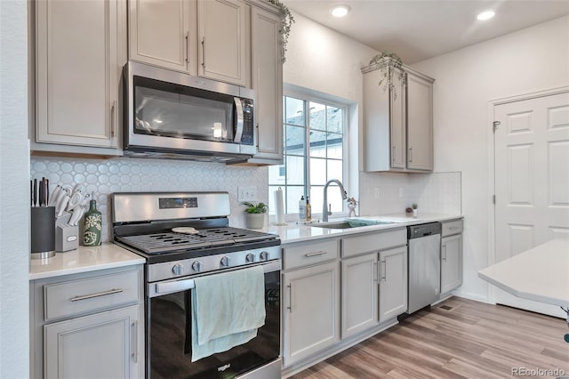 3963 N Quatar Ct, Aurora, CO 80019 - kitchen featuring appliances with stainless steel finishes, a sink, decorative backsplash, light countertops, and recessed lighting