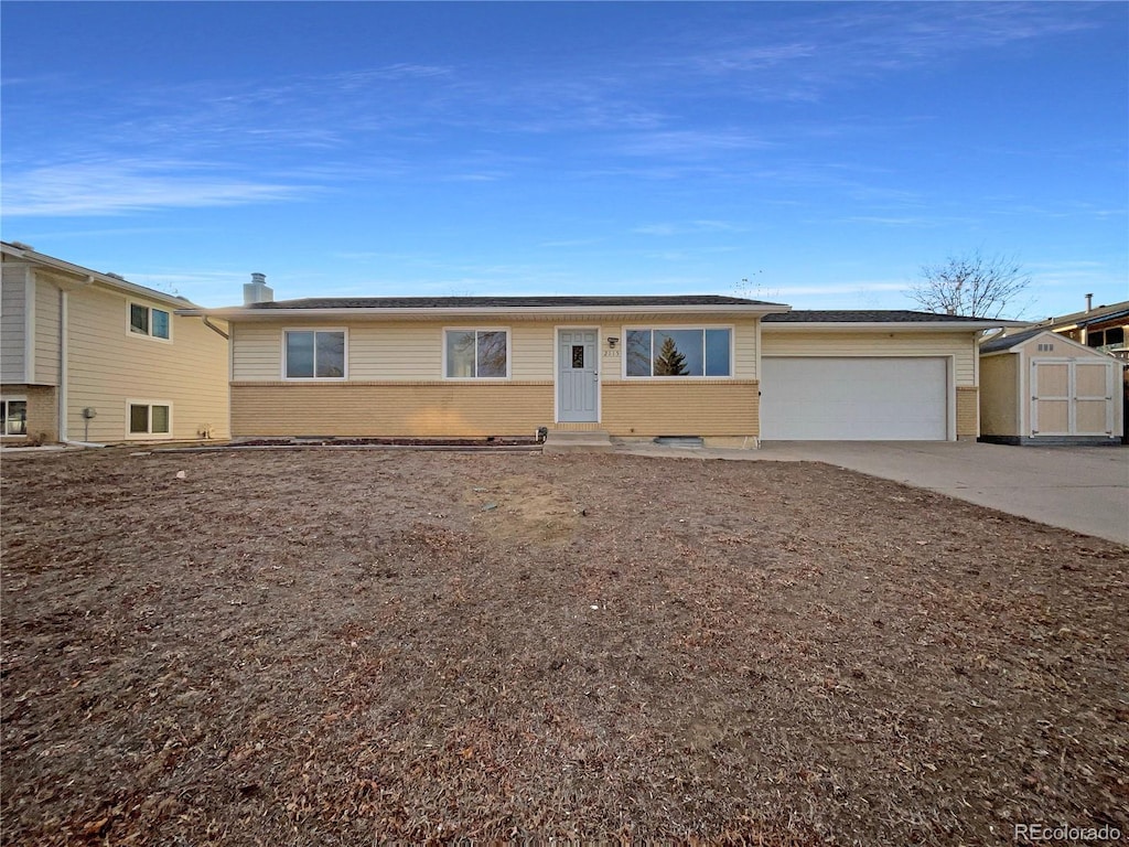 ranch-style house with a storage shed and a garage