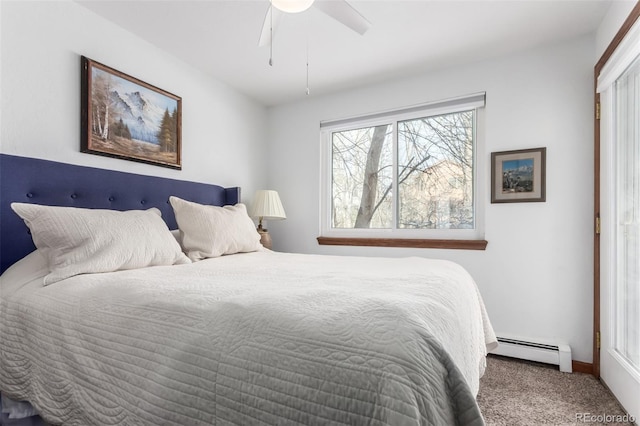 carpeted bedroom featuring baseboard heating and a ceiling fan