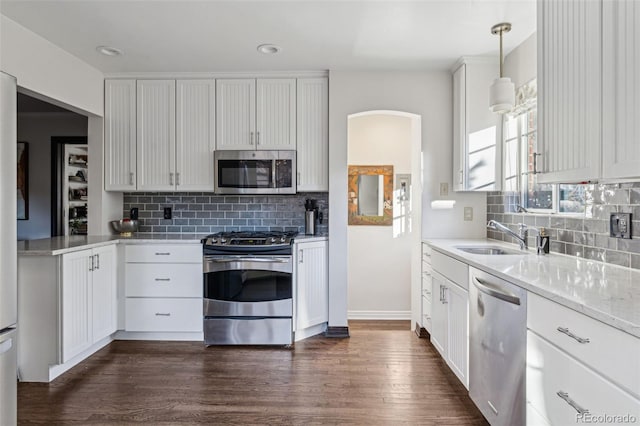 kitchen featuring sink, stainless steel appliances, hanging light fixtures, and white cabinetry