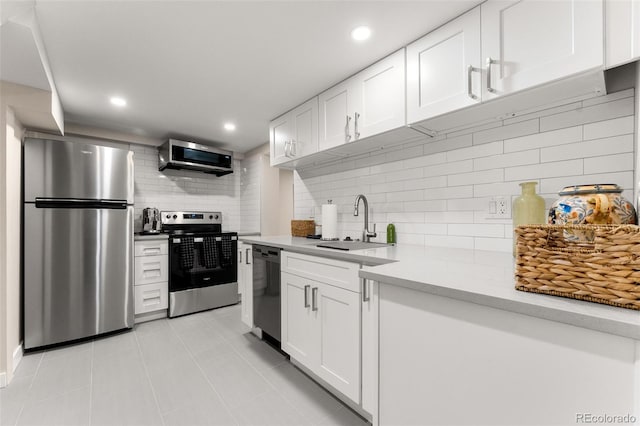 kitchen featuring sink, appliances with stainless steel finishes, decorative backsplash, and white cabinetry