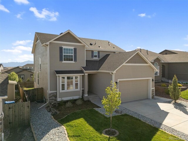 8235 Ryegate Way, Colorado Springs, CO 80908 - view of front of property featuring a garage, concrete driveway, stone siding, and roof with shingles