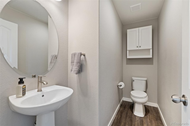8235 Ryegate Way, Colorado Springs, CO 80908 - half bathroom with wood finished floors, toilet, baseboards, and a sink