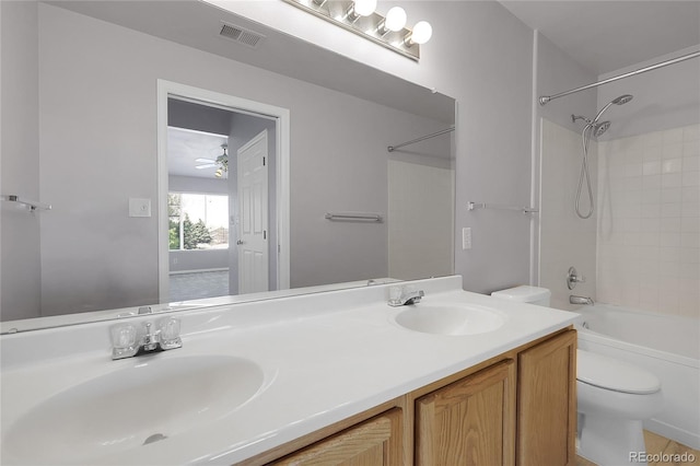 bathroom with toilet, double vanity, bathtub / shower combination, and ceiling fan