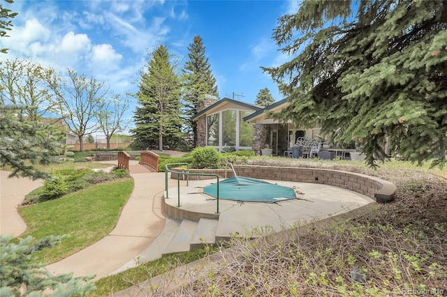 view of swimming pool featuring a covered pool and a patio