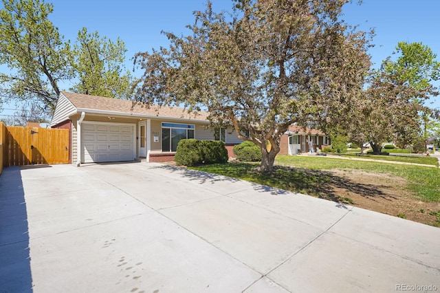 ranch-style house with driveway, brick siding, fence, a garage, and a front lawn
