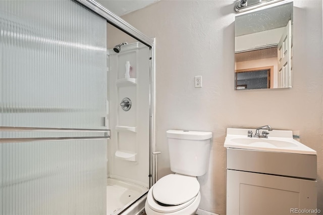 full bathroom featuring toilet, a shower stall, and vanity