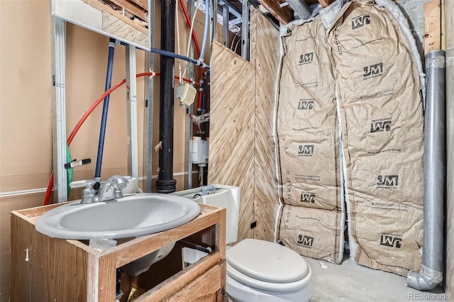 half bathroom with unfinished concrete flooring, a sink, and toilet