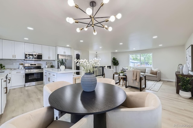 6876 Quay Ct, Arvada, CO 80003 - dining area with a chandelier, light wood finished floors, recessed lighting, and baseboards