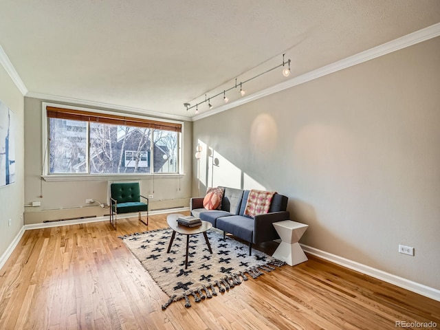 living room featuring ornamental molding, track lighting, and hardwood / wood-style floors