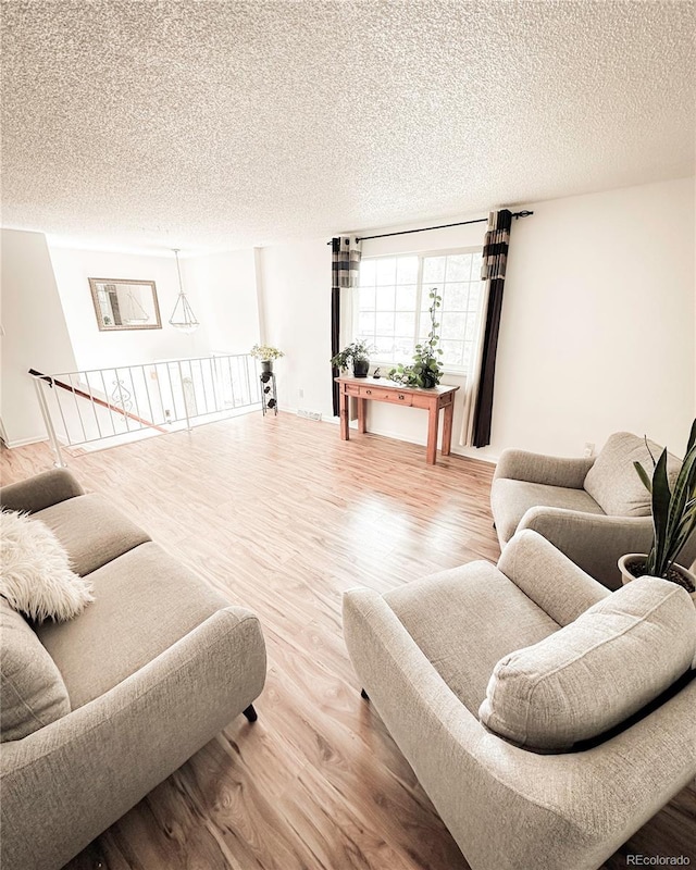 living area with a textured ceiling and wood finished floors