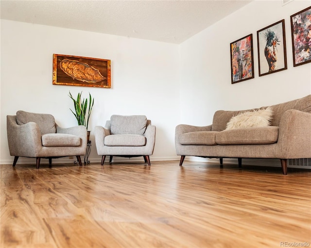living area featuring baseboards and light wood finished floors