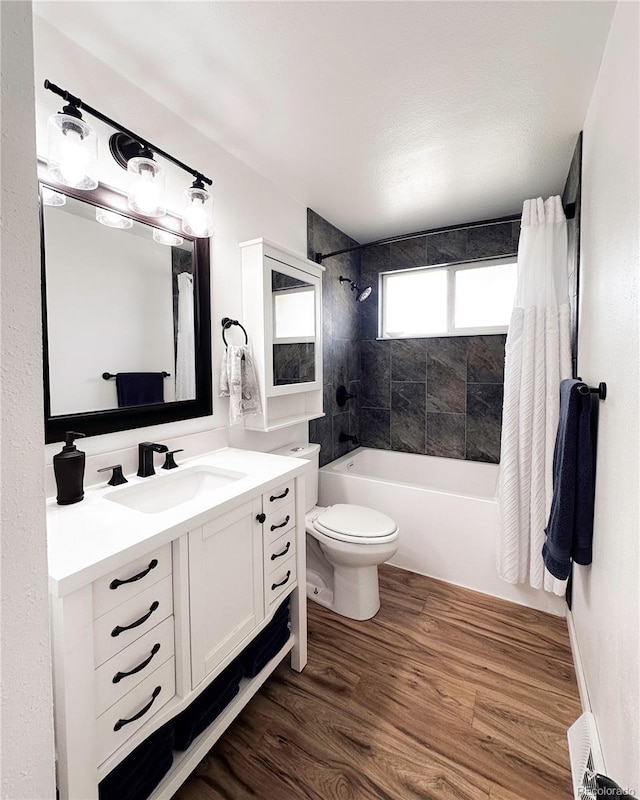 full bath featuring baseboard heating, shower / tub combination, wood finished floors, vanity, and toilet