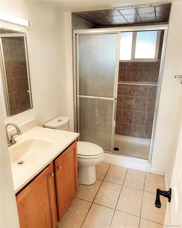 full bath featuring vanity, tile patterned flooring, toilet, and a shower stall