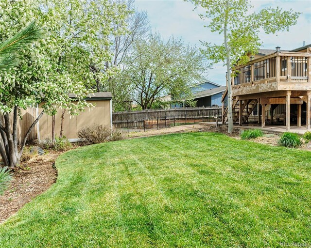 view of yard with stairway, a deck, and a fenced backyard