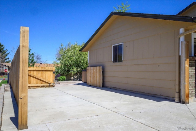 view of side of home featuring a patio and fence