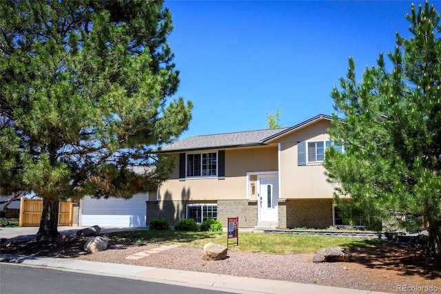 raised ranch with brick siding and an attached garage
