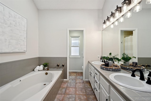 bathroom featuring vanity and tiled tub