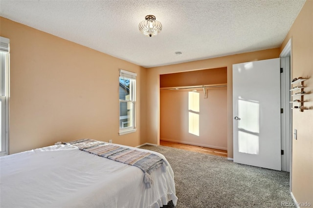 carpeted bedroom featuring a textured ceiling and a closet