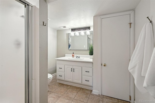 bathroom featuring vanity, a textured ceiling, and toilet