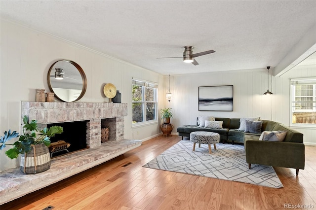 living room with a fireplace, a textured ceiling, and a healthy amount of sunlight