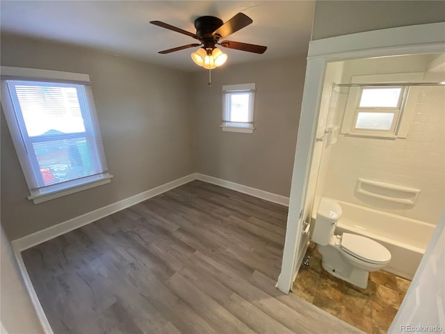 bathroom with ceiling fan, shower / bath combination, wood-type flooring, and toilet