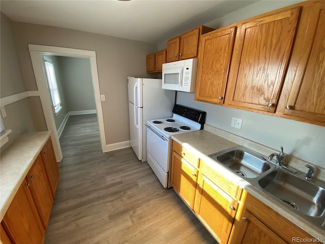 kitchen featuring sink, white appliances, and light hardwood / wood-style flooring