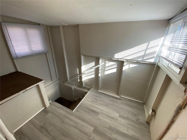 staircase featuring wood-type flooring and vaulted ceiling