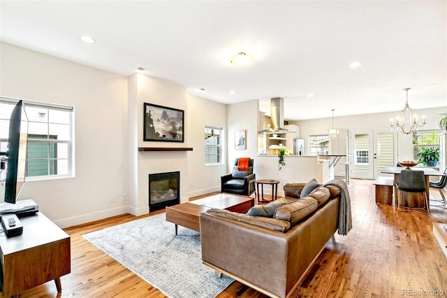 4530 Quitman St, Denver, CO 80212 - living area featuring light wood-type flooring, baseboards, a glass covered fireplace, recessed lighting, and an inviting chandelier