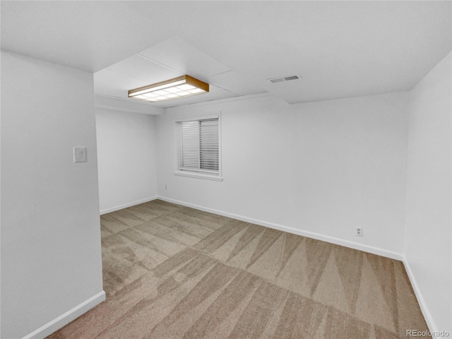 carpeted spare room featuring visible vents and baseboards