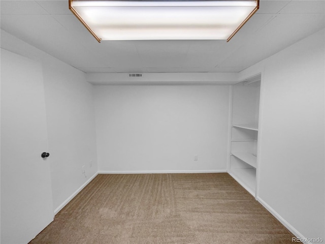 empty room featuring baseboards, visible vents, and carpet flooring