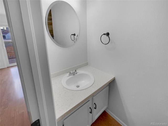 bathroom featuring wood finished floors, vanity, and baseboards