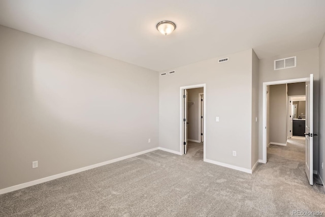 unfurnished bedroom featuring a walk in closet and light carpet