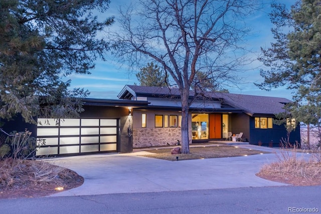 view of front facade with an attached garage, driveway, and stucco siding