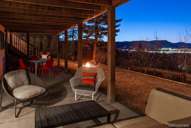 view of patio / terrace with fence and a mountain view