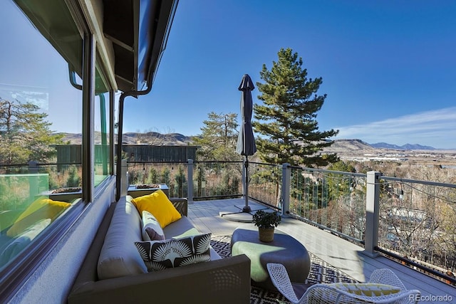 view of patio featuring an outdoor living space, a mountain view, and a balcony