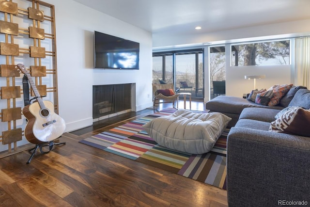 living area with recessed lighting, baseboards, wood finished floors, and a fireplace