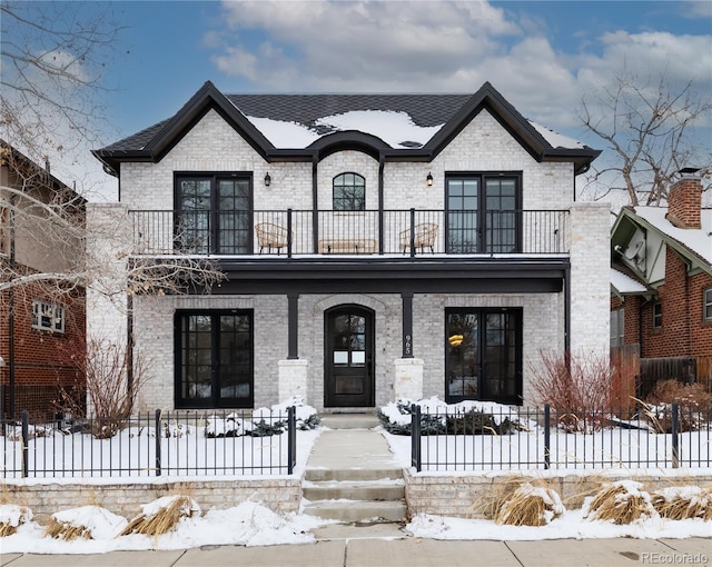 french country home featuring covered porch and a balcony