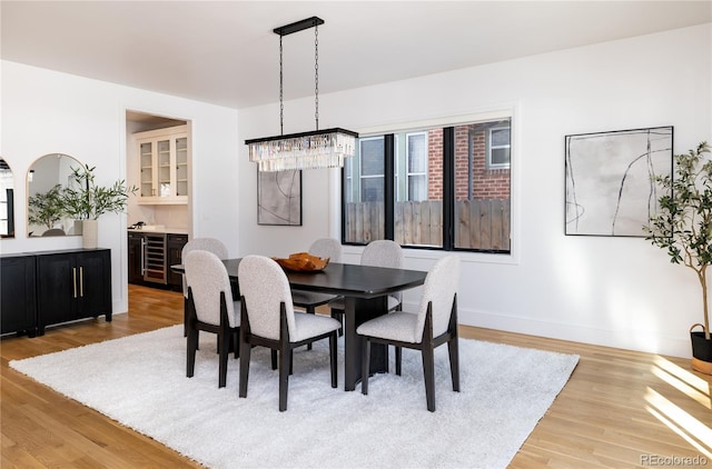 dining space with light wood-type flooring and wine cooler