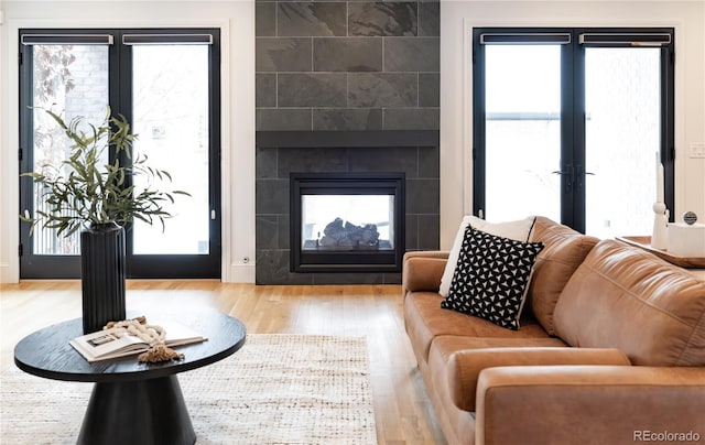 living room with a fireplace, hardwood / wood-style flooring, and french doors